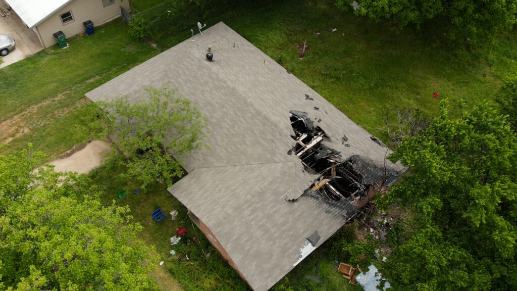 Aerial view of the home on Kinson Street in Granbury, TX that was devastated by a house fire before Wannco Services demolished the structure. It shows the hole in the roof from the fire damage.
