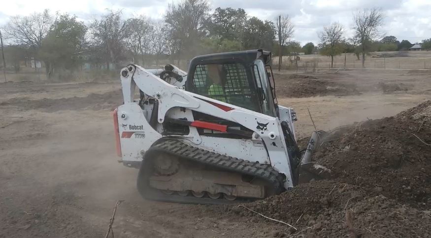 A Wannco grader doing dirt work at a site clearing property