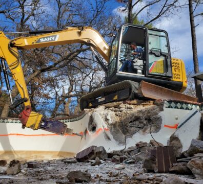 An excavator working on a pool demolition project in Granbury