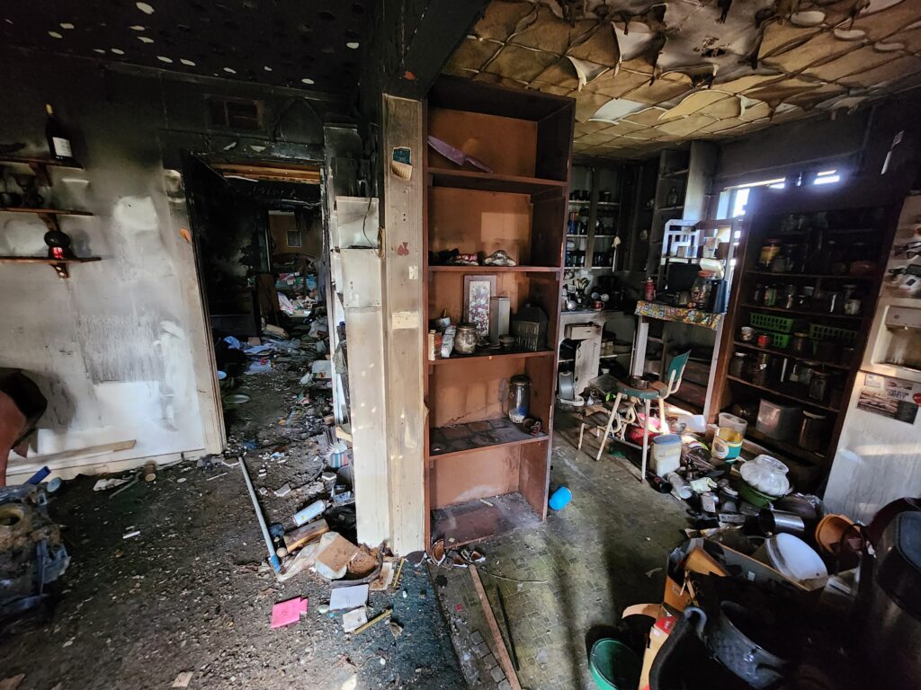 Inside of a home that has severe smoke damage from a house fire, prior to full demolition.