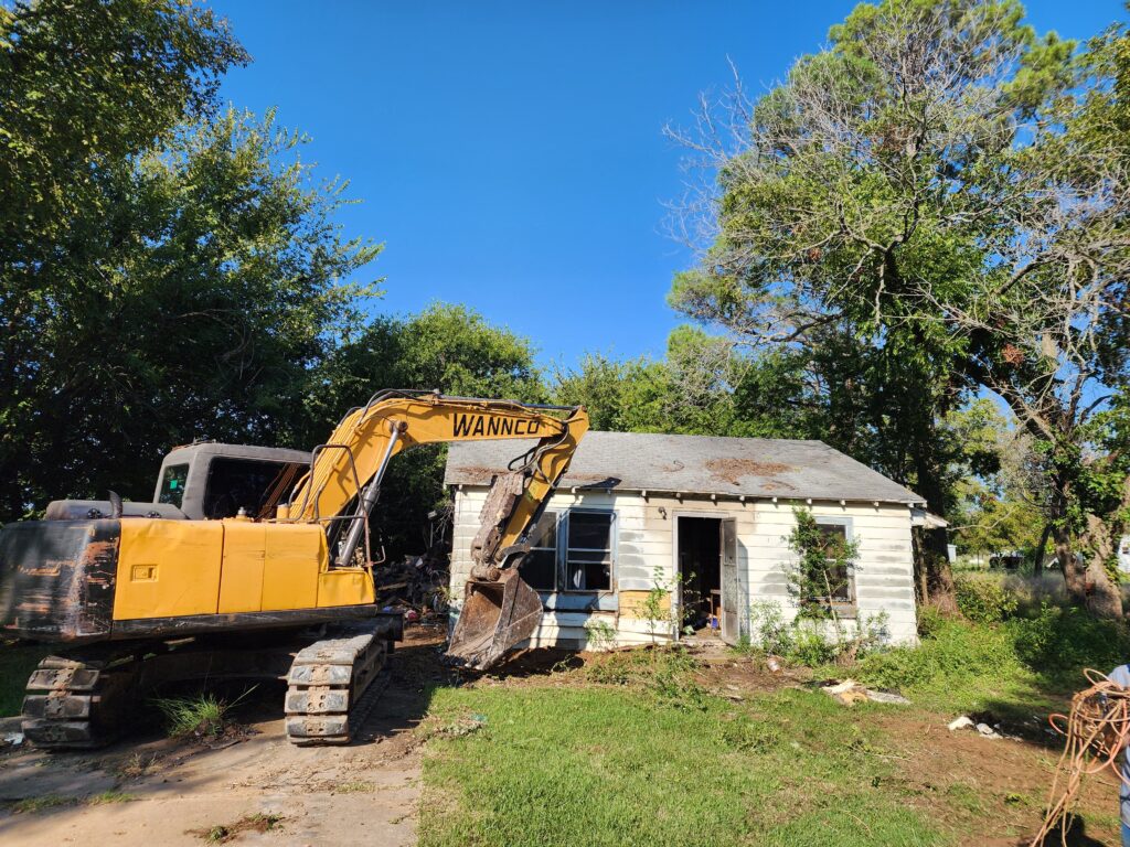 Wannco Services excavator prior to tearing down a burned out home in Tolar