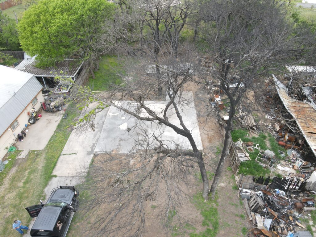 Cleared concrete slab after fire-damaged home demolition by Wannco Services in Granbury, TX
